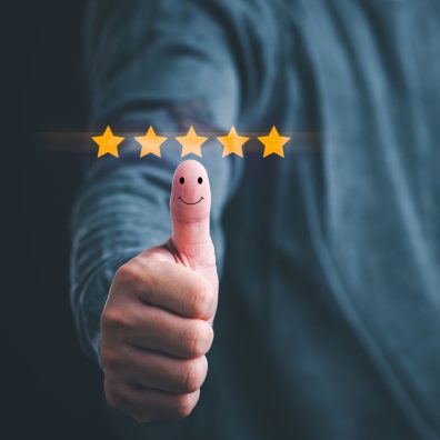 Customer satisfaction concept. Hand with thumb up Positive emotion smiley face icon and five star with copy space.